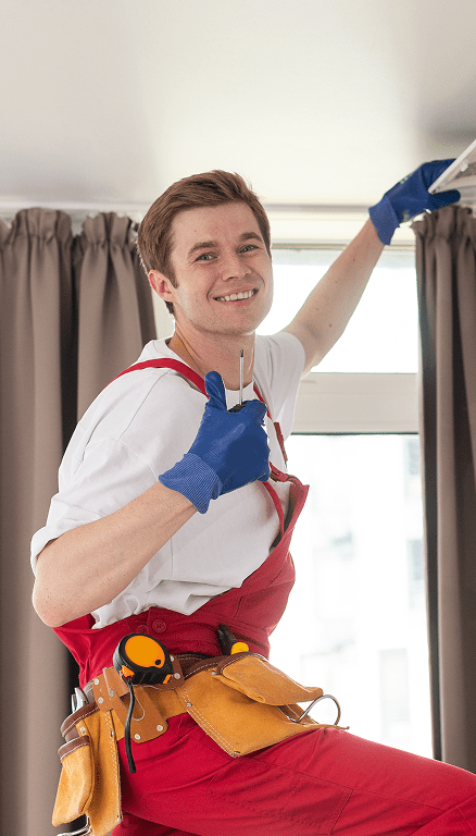 Smiling worker with tools giving thumbs up.
