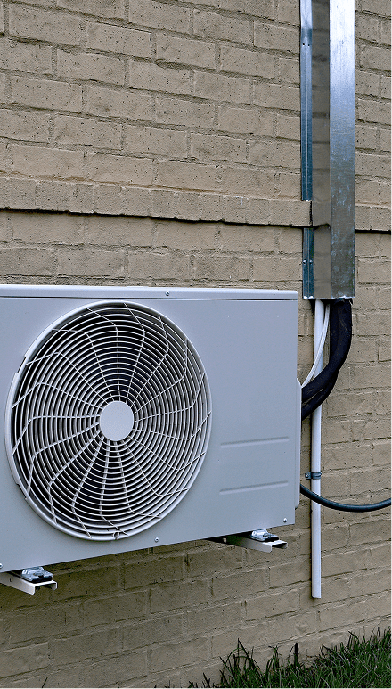 Air conditioning unit mounted on brick wall.