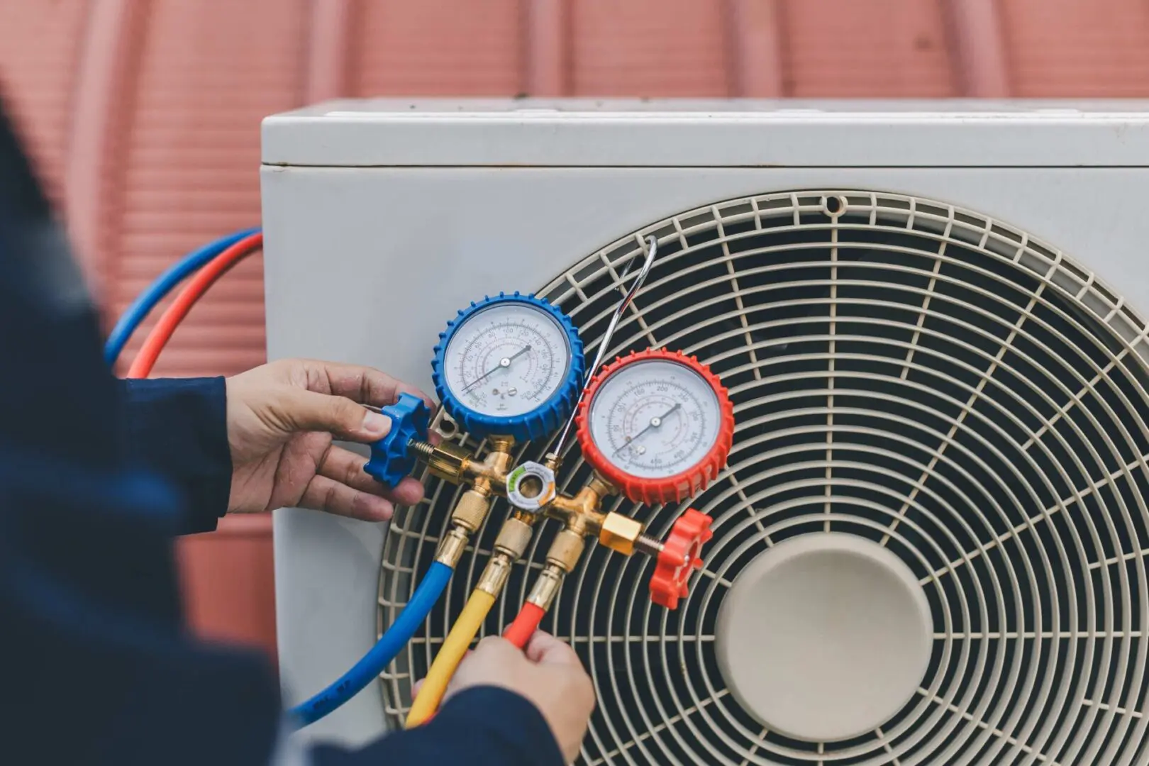 Technician checking air conditioning unit gauges.